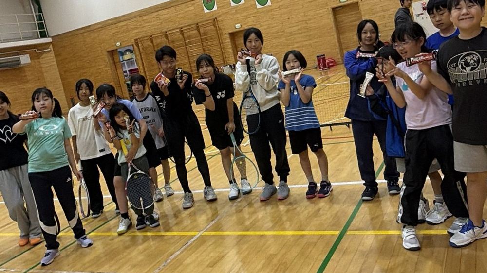 体育館でラケットを持って並ぶTLCの子どもたち